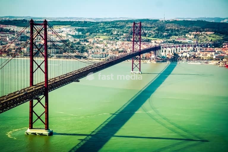 25 de Abril Bridge spans the Tagus River, Lisbon, Portugal, suspension bridge over turquoise water