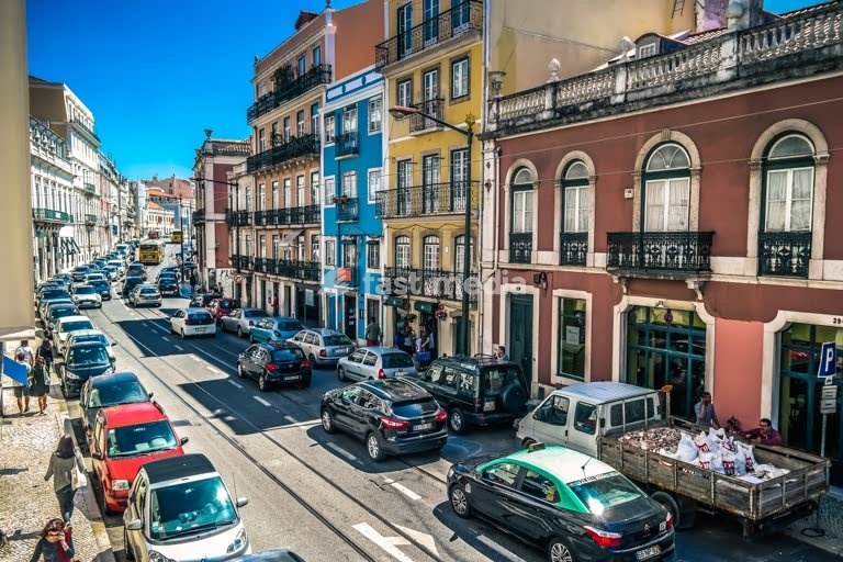 Busy street in Príncipe Real with colorful facades and traffic, Lisbon, Portugal, sunny day