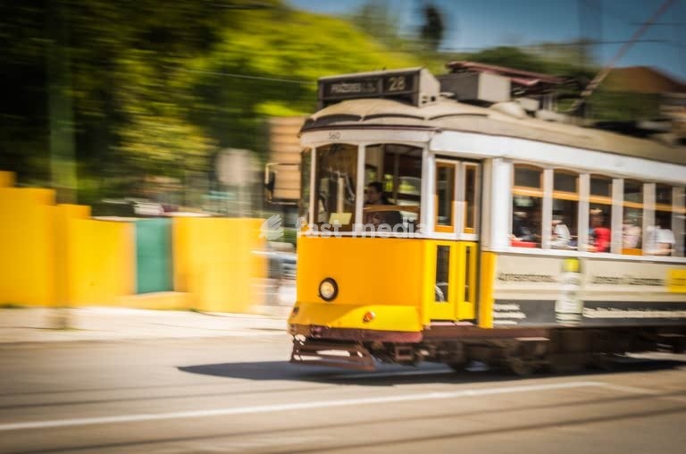 Iconic yellow Tram 28 speeds through Lisbon in motion blur, Portugal