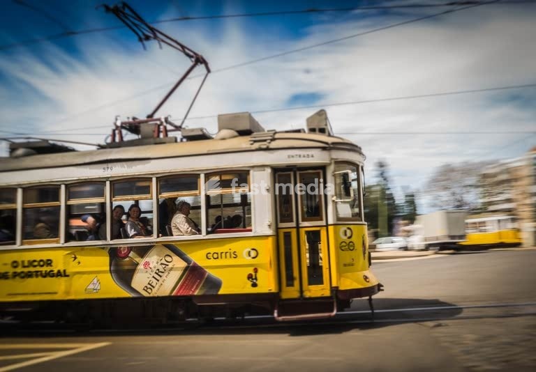 Iconic yellow Tram 28 speeds through Lisbon in motion blur, Portugal
