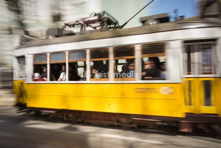 Iconic yellow Tram 28 speeds through Lisbon in motion blur, Portugal