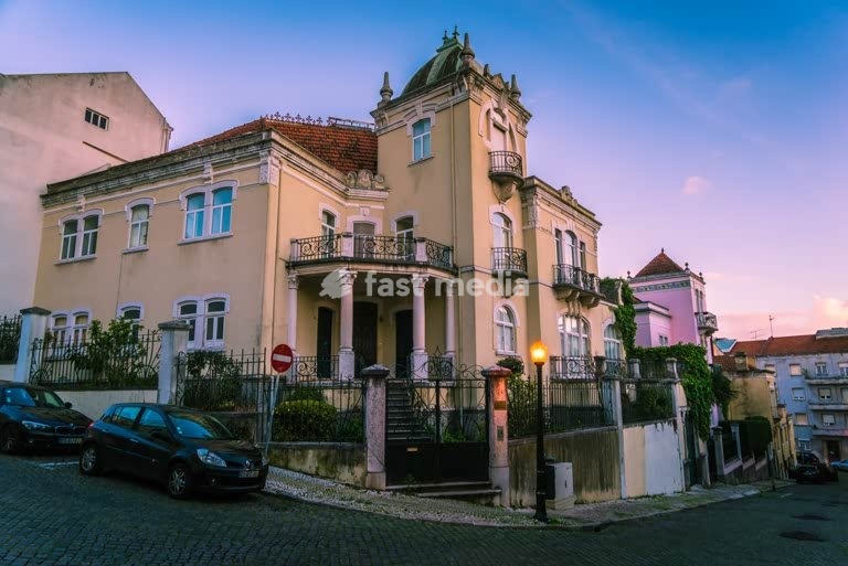 Eclectic-revival villa with corner turret at twilight, Lapa, Lisbon, Portugal, c. early 20th century