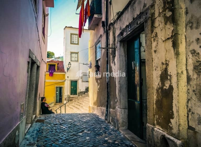 Women chatting in a narrow alley in the arabic rooted Alfama neighborhood, Lisbon