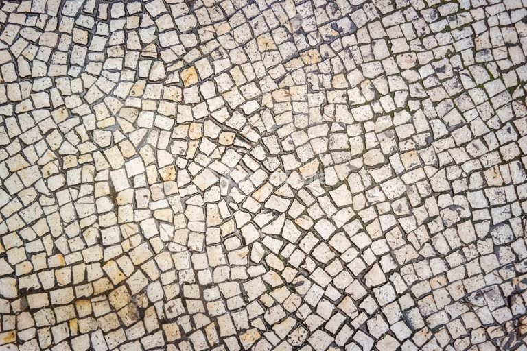 Traditional Portuguese cobblestone pavement, calçada portuguesa texture, close-up mosaic pattern