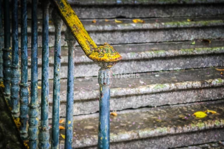 Weathered yellow handrail on staircase at Palácio do Monteiro-Mor, Lisbon, Portugal - aged architecture detail with peeling paint