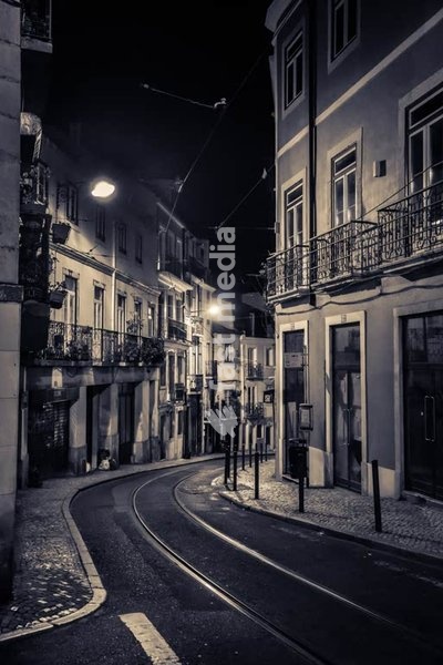 Lisbon, Portugal, cobblestone street Rua Poias de São Bento at night with traditional Portuguese architecture and iron balconies