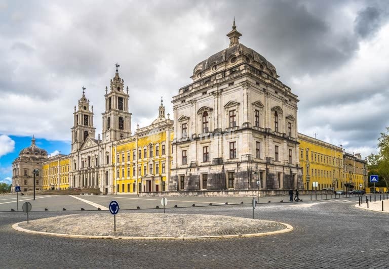 Mafra National Palace, Portugal. Grand baroque and neoclassical royal complex with basilica and twin towers under a blue sky. UNESCO World Heritage
