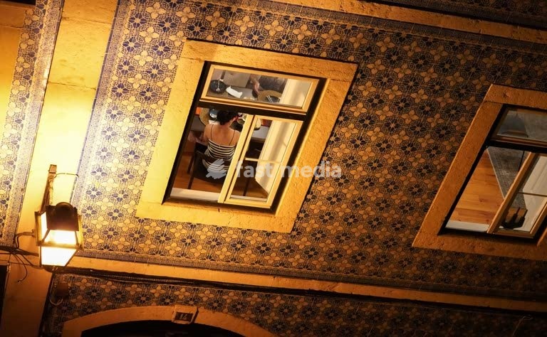 Traditional Portuguese apartment interior with ornate azulejo tile walls and vintage lantern lighting in historic Lisbon, Bairro Alto, Portugal