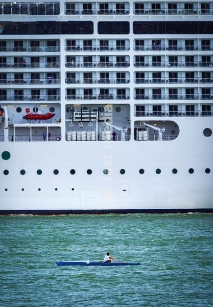 Small rowing boat next to a huge cruise ship on the Tagus in Lisbon, Portugal, where overtourism has become an issue. Photo Peter Delius