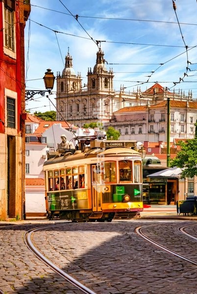 Old tram at Largo Portas do Sol in Lisbon’s Alfama district, Portugal. Sao Vicente church in the back