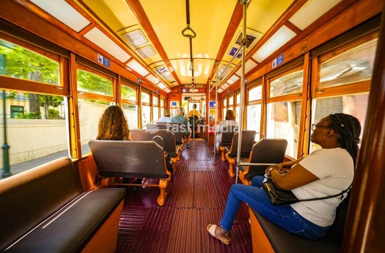 Interior of a historic Lisbon tram 18E with passengers enjoying a scenic ride through the city. Vintage charm