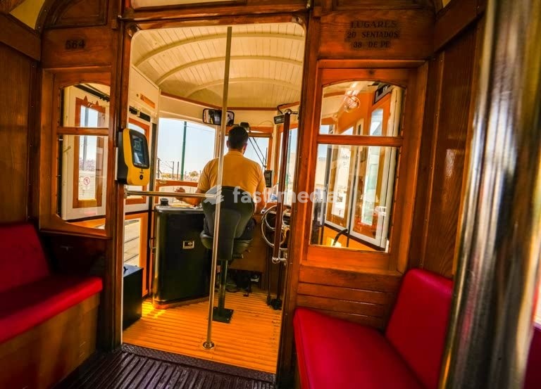 Driver at the controls of a historic Lisbon tram 18E, capturing the vintage interior and timeless charm of one of Portugal’s most iconic transports