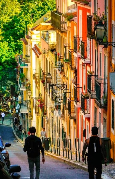 Colorful facades and wrought iron balconies in a steep street of Lisbon’s Bairro Alto district. Sunny afternoon in Portugal’s capital