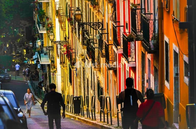 Colorful facades and wrought iron balconies in a steep street of Lisbon’s Bairro Alto district. Sunny afternoon in Portugal’s capital