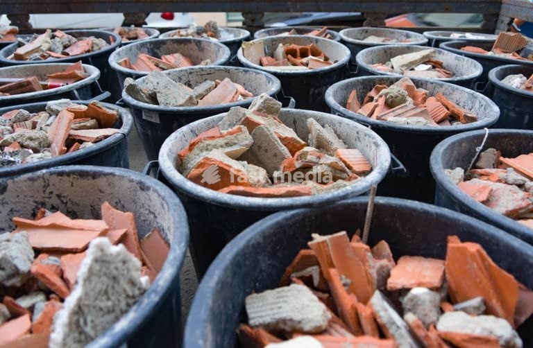 Buckets filled with broken terracotta tiles and ceramic fragments from building demolition or renovation work in Lisbon, Portugal, Europe