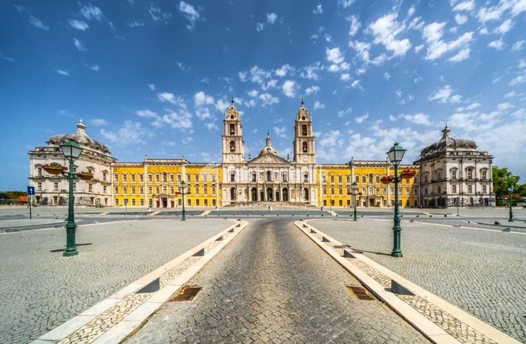 Mafra National Palace, Portugal. Grand baroque and neoclassical royal complex with basilica and twin towers under a blue sky. UNESCO World Heritage