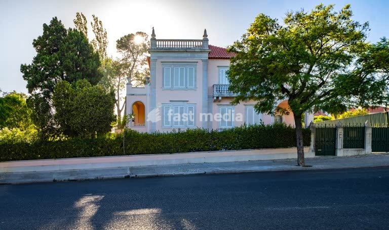 Elegant Portuguese villa with neoclassical facade on Avenida da Torre de Belém, Lisbon, featuring traditional blue shutters and ornate details
