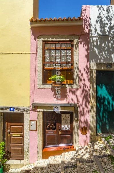 Charming tiny pink house in a narrow street of Lisbon’s Bairro Alto district, with cobblestone steps and traditional Portuguese architecture