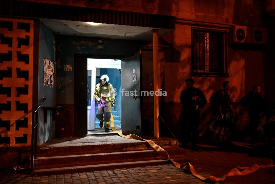 A firefighter of the State Emergency Service of Ukraine carrying a flashlight walks out of the entrance of a nine-story residential building during efforts to eliminate the aftermath of a Russian strike in the Kosmichnyi district of Zaporizhzhia, Ukraine, on October 5, 2026. Five people were…
