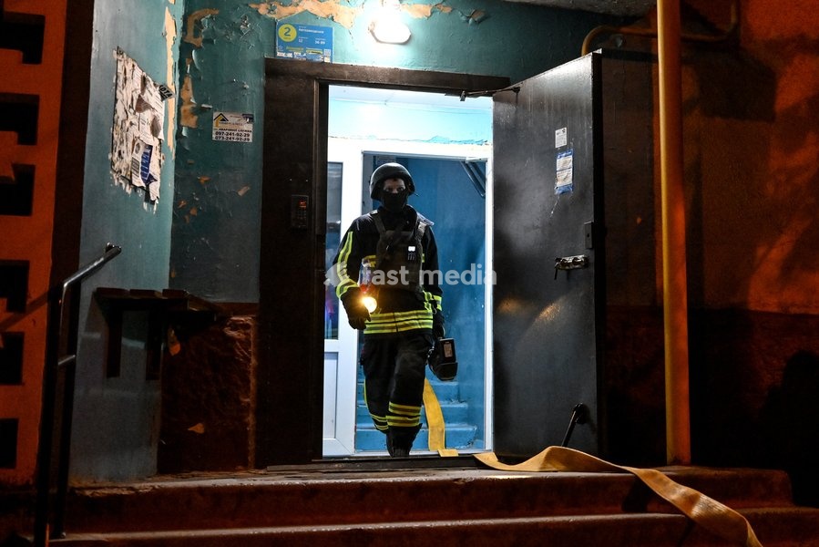 A rescuer of the State Emergency Service of Ukraine carrying a flashlight walks out of the entrance of a nine-story residential building during efforts to eliminate the aftermath of a Russian strike in the Kosmichnyi district of Zaporizhzhia, Ukraine, on October 5, 2026. Five people were injured in…
