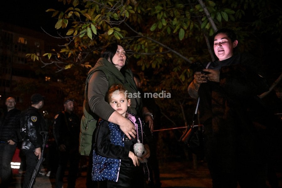 A family evacuated by rescuers from a blocked apartment on the fifth floor of a nine-story residential building hit by a Russian drone is seen in the Kosmichnyi district of Zaporizhzhia, Ukraine, on October 5, 2026. Five people were injured in the Russian attack, one of them seriously. Rescuers…