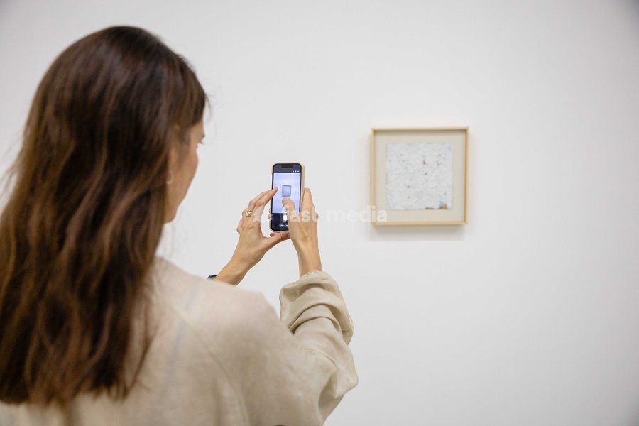 A painting of six strokes in the lower right corner, signed left center in flesh orange and top in neutral, measuring 10" x 10", 1961 on display at Robert Ryman: The Real Thing at the Barbican Art Gallery, London, UK, on 7 October 2026. The first significant UK exhibition of American minimalist and…
