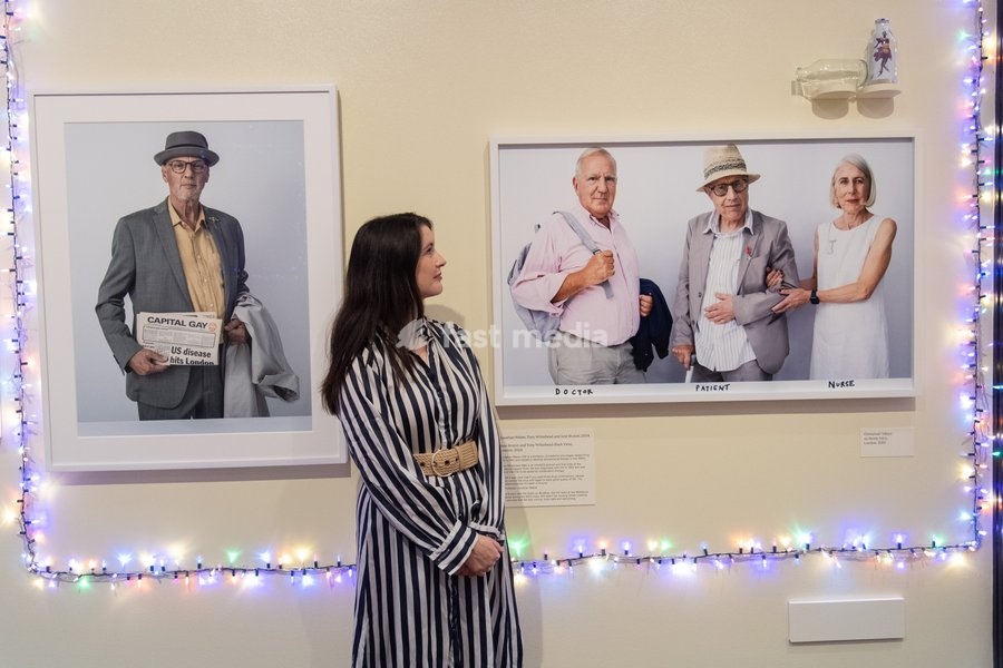 A staff member views (L) - 'Graham McKerrow Holds First News Report on HIV in the UK' and (R) - 'Jonathan Weber, Tony Whitehead and Jane Bruton' all by Tim Walker as part of The National Portrait Gallery's 'Tim Walker's Fairyland: Love and Legends' Exhibition which runs from 9th October 2026 - 7th…