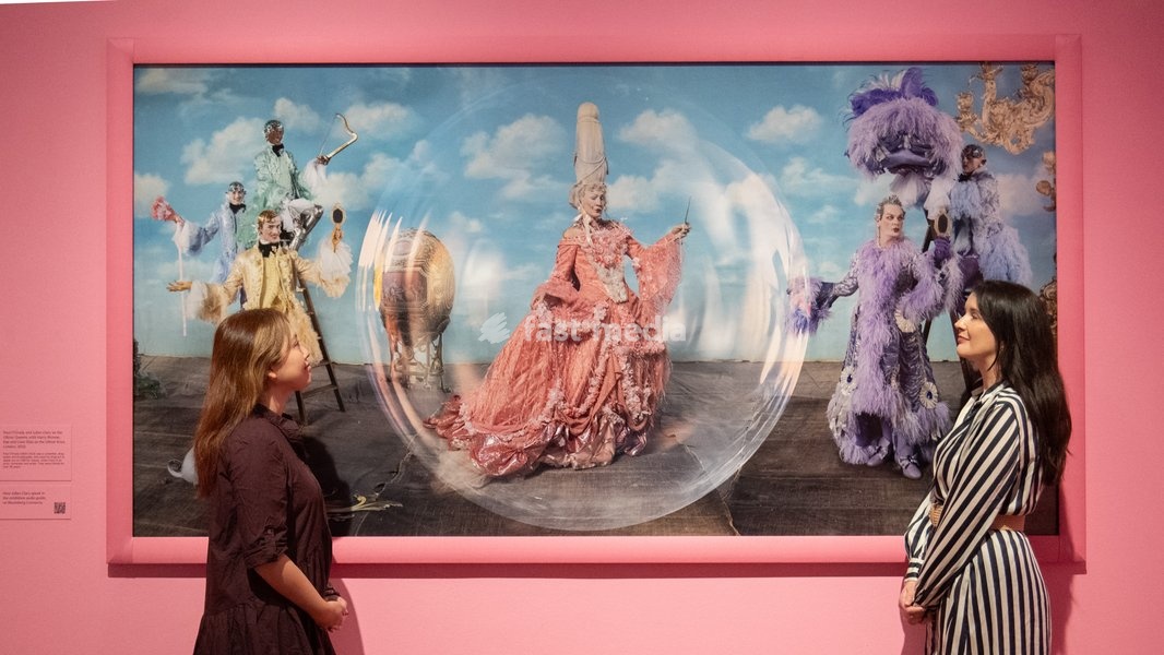 A staff member views 'Paul O'Grady and Julian Clary as the Glitter Queens, with Harry Browse, Rae and Liam Elias as the Glitter Boys' by Tim Walker as part of The National Portrait Gallery's 'Tim Walker's Fairyland: Love and Legends' Exhibition which runs from 9th October 2026 - 7th February 2027…