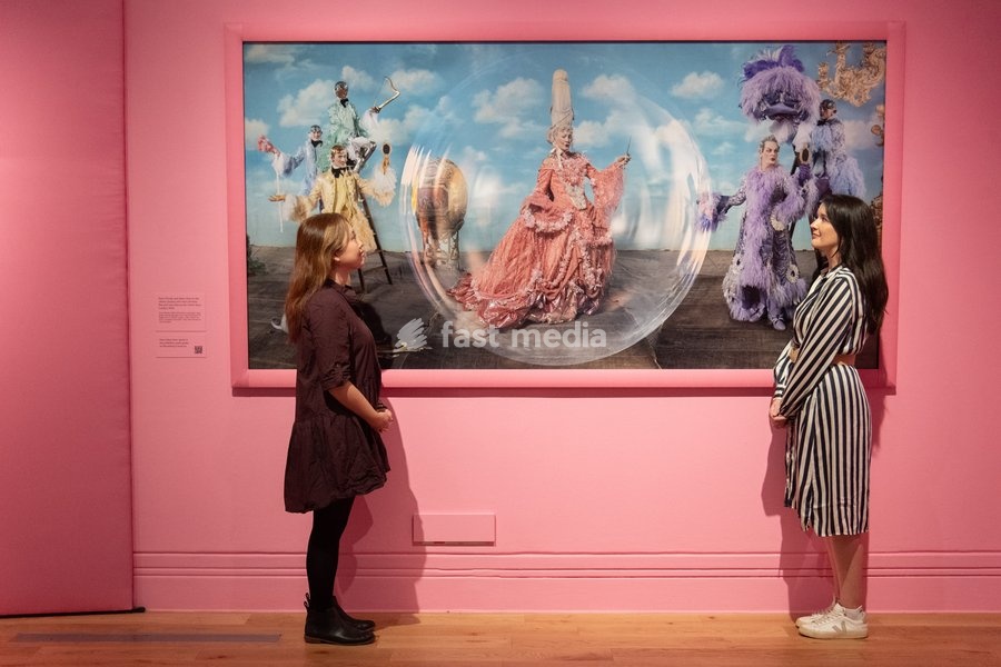 A staff member views 'Paul O'Grady and Julian Clary as the Glitter Queens, with Harry Browse, Rae and Liam Elias as the Glitter Boys' by Tim Walker as part of The National Portrait Gallery's 'Tim Walker's Fairyland: Love and Legends' Exhibition which runs from 9th October 2026 - 7th February 2027…