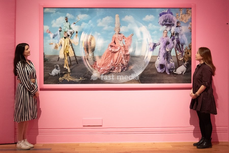 A staff member views 'Paul O'Grady and Julian Clary as the Glitter Queens, with Harry Browse, Rae and Liam Elias as the Glitter Boys' by Tim Walker as part of The National Portrait Gallery's 'Tim Walker's Fairyland: Love and Legends' Exhibition which runs from 9th October 2026 - 7th February 2027…