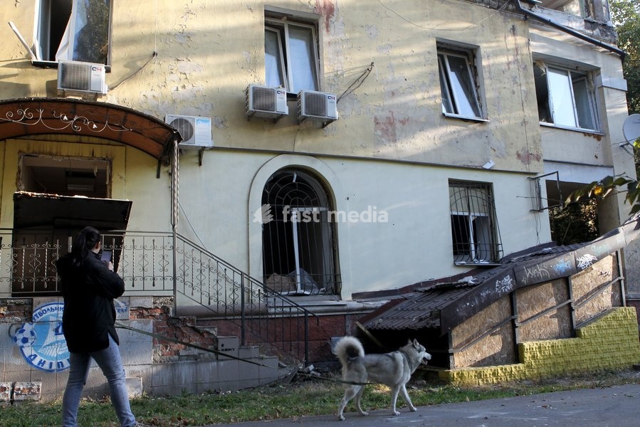 A man with a dog walks past a building damaged in a Russian missile strike, Dnipro, Ukraine, on October 6, 2026. Russian forces attacked Dnipro with missiles, damaging an industrial enterprise, apartment buildings, and a sports club