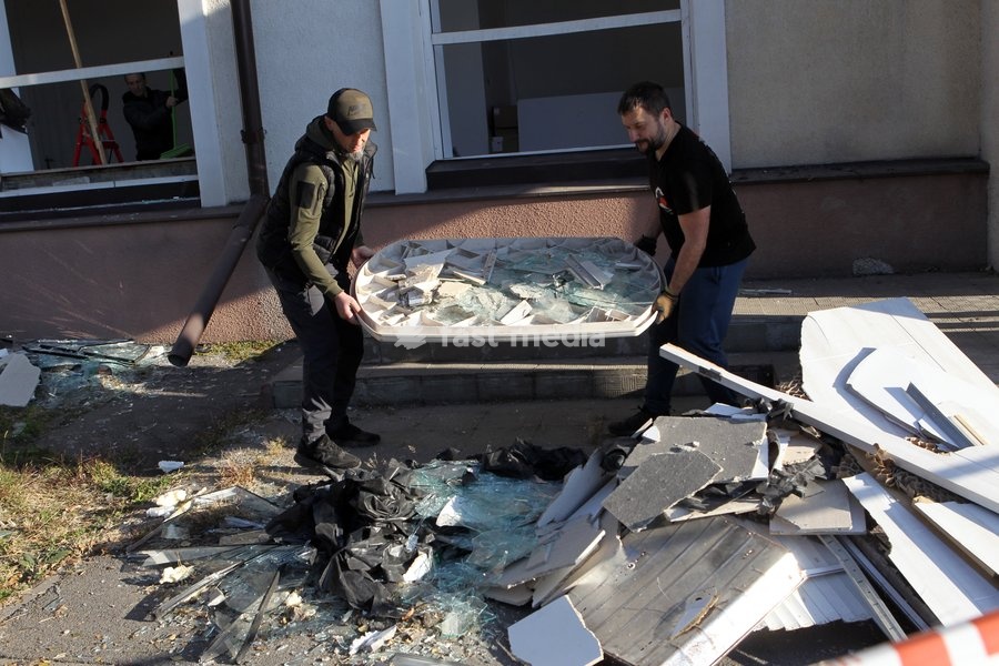 Men work to eliminate the aftermath of a Russian missile strike near a damaged building, Dnipro, Ukraine, on October 6, 2026. Russian forces attacked Dnipro with missiles, damaging an industrial enterprise, apartment buildings, and a sports club