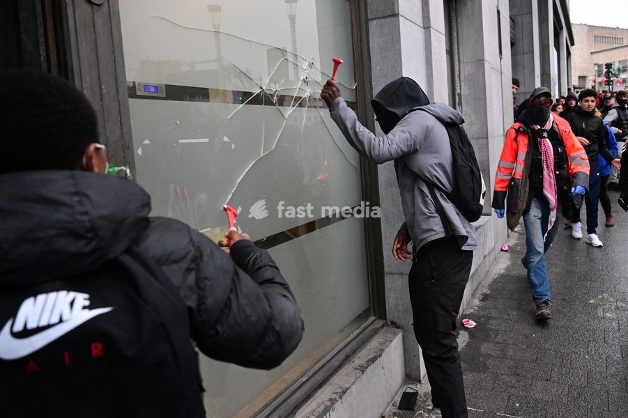 Protesters smash a window during a national manifestation against the Federal Government's budgetary measures, under the 'Keep your hands out of our pockets!' (Blijf uit onze zakken! - Pas dans nos poches) moniker, organised by the trade unions on Friday 9 October 2026 in Brussels