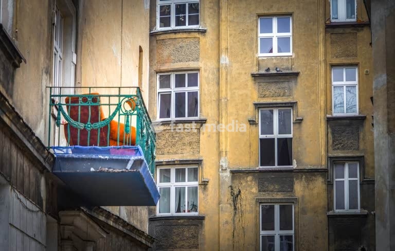 Colorful balcony in quiet courtyard, vivid everyday life contrasting with anonymous apartment façades and routine