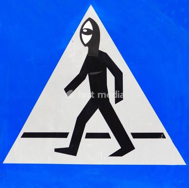 Altered pedestrian crossing sign, urban collage art, Poznań, Poland, humorous intervention on traffic symbol