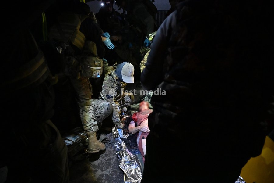 CAUTION, SENSITIVE CONTENT. A volunteer with the medical volunteer unit Crew13 stands near the body of a person killed in a Russian missile strike on a nine-story residential building in Kyiv’s Desnianskyi district, Ukraine, on October 14, 2026. Russia launched a massive ballistic missile attack on…