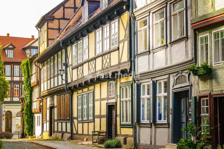 Medieval half-timbered houses line cobblestone street in historic Quedlinburg, Germany - UNESCO World Heritage Site with traditional architecture