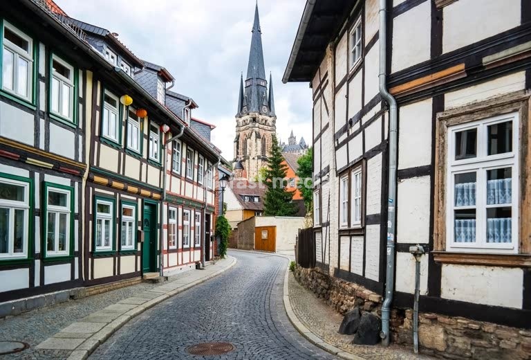 Medieval half-timbered houses line cobblestone street in historic Quedlinburg, Germany - UNESCO World Heritage Site with traditional architecture