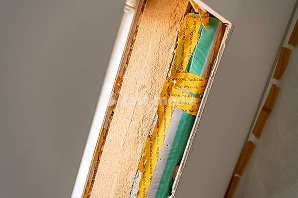 Open skylight opening with insulation panels, green foil and yellow adhesive tape in unfinished interior construction, old building renovation, Stuttgart, Baden-Württemberg, Germany