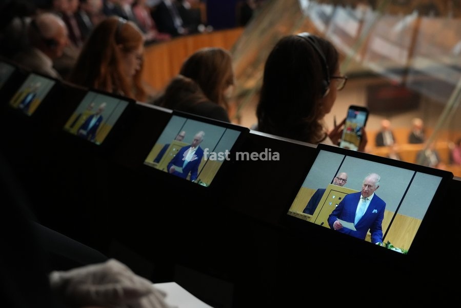 Britain's King Charles III is seen on small screens as he speaks during the Ceremonial Opening of the Seventh Senedd in Cardiff, Wales, Thursday, Oct. 15, 2026