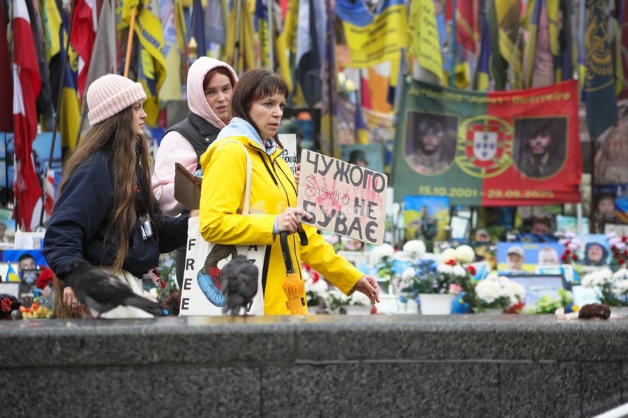 An activist carries a placard past a memorial in Maidan Nezalezhnosti (Independence Square) during the weekly “Don’t Stay Silent! Captivity Kills” rally in support of Ukrainian military personnel held in Russian captivity or listed as missing in action, Kyiv, Ukraine, October 18, 2026