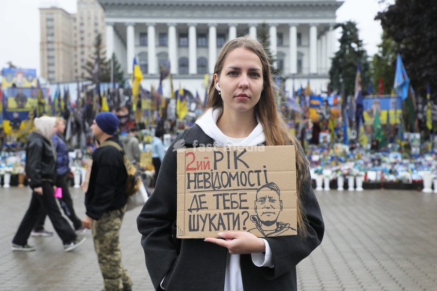 An activist holds a placard reading "2 Years of Uncertainty. Where Should I Look for You?" while standing outside a memorial in Maidan Nezalezhnosti (Independence Square) during the weekly “Don’t Stay Silent! Captivity Kills” rally in support of Ukrainian military personnel held in Russian…