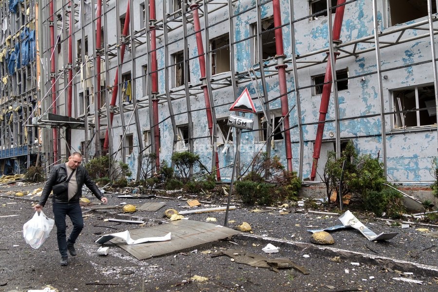 A man carries a bag past a building in the Solomianskyi district damaged by a Russian attack, Kyiv, Ukraine, October 19, 2026. During the night and morning, Russia launched a massive strike on the capital using ballistic missiles, cruise missiles, and drones. According to Kyiv city head Vitali…