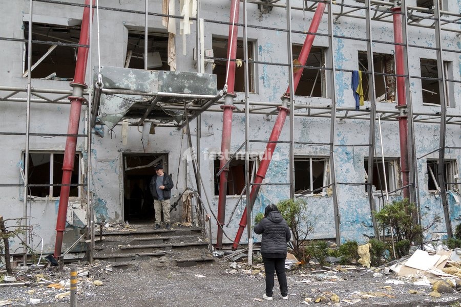 People stand outside a building in the Solomianskyi district damaged by a Russian attack, Kyiv, Ukraine, October 19, 2026. During the night and morning, Russia launched a massive strike on the capital using ballistic missiles, cruise missiles, and drones. According to Kyiv city head Vitali…
