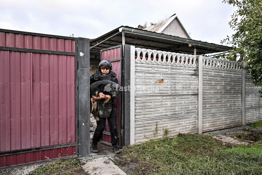 A volunteer carries a rescued dog to a minibus during a humanitarian evacuation mission in the front-line settlement of Komyshuvakha, Zaporizhzhia region, Ukraine, October 19, 2026