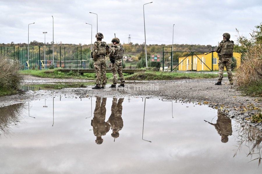 Zaporizhzhian police officers stand by a puddle in the street during a humanitarian evacuation mission for a family, including an elderly woman with limited mobility, Zaporizhzhia region, Ukraine, October 19, 2026