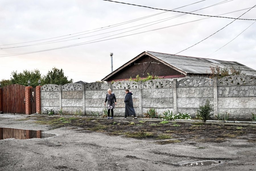 Two women walk down a street in the front-line settlement of Komyshuvakha, Zaporizhzhia region, Ukraine, October 19, 2026