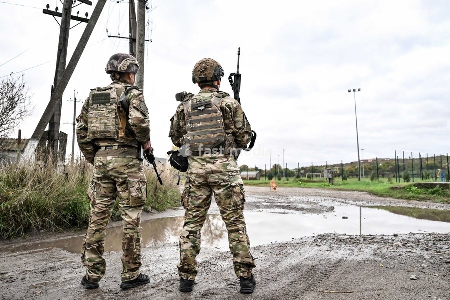 Zaporizhzhian police officers stand by a puddle in the street during a humanitarian evacuation mission for a family, including an elderly woman with limited mobility, Zaporizhzhia region, Ukraine, October 19, 2026
