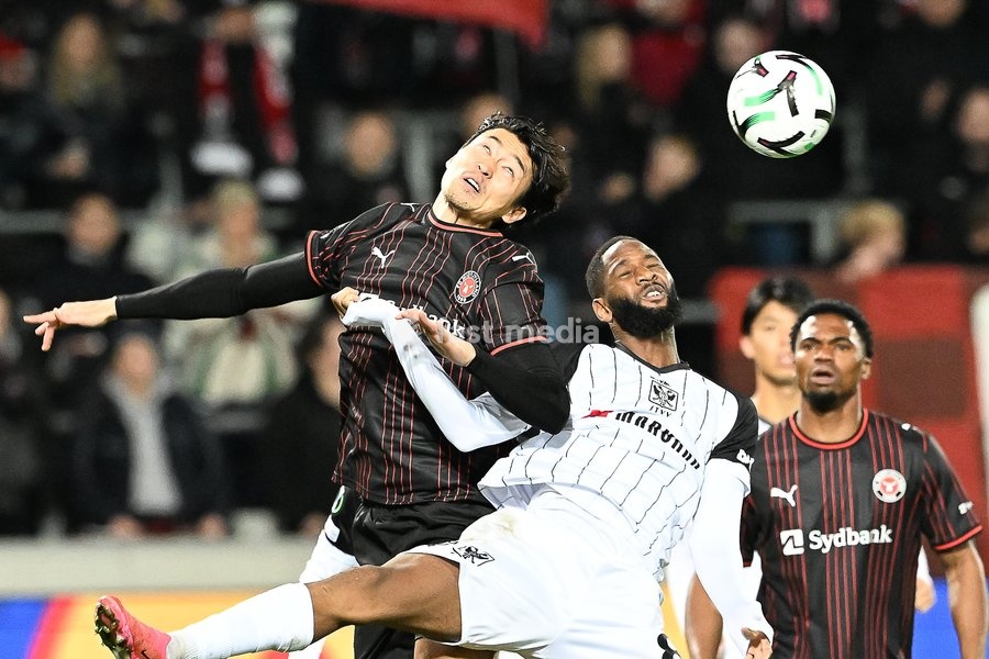 Midtjylland's Cho Gue-sung and STVV's Abdoulaye Sissako pictured in action during a soccer game between Danish FC Midtjylland and Belgian Sint-Truidense VV, Thursday 22 October 2026 in Herning, Denmark, on the second day of the UEFA Conference League league phase