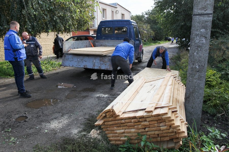 Volunteers unload planks near houses damaged by a Russian attack, Dnipro, Ukraine, October 22, 2026. According to city head Borys Filatov, 11 private houses were damaged in the strike on Thursday morning, and one home burned down completely